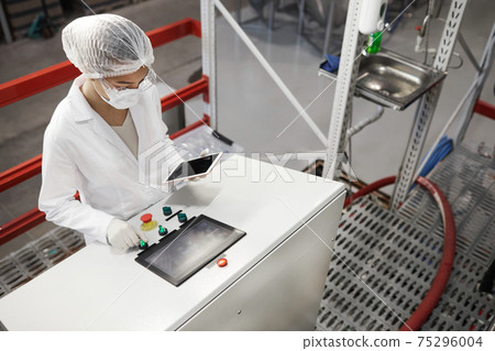 Young Woman Operating Machines at Pharmaceutical Factory 75296004