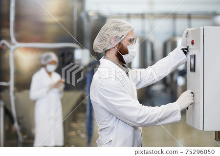 Male Worker Setting Up Equipment at Chemical Factory Male Worker Setting Up Equipment at Chemical Factory 75296050