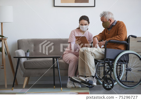 Female Caregiver Assisting Senior Man in Wheelchair Female Caregiver Assisting Senior Man in Wheelchair 75296727