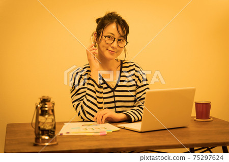 A woman in her thirties teleworking at night 75297624