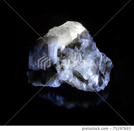 Shiny luminous transparent calcite mineral crystal from Alchak, Crimea. A backlight photo of a stone isolated on black. Geology websites, stone collection catalog, Natural Science museum wall chart 75297683