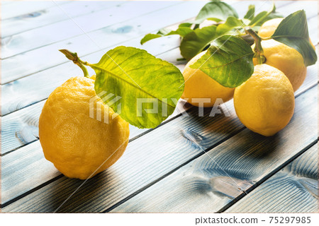 Ripe lemons over an old wooden table. Agriculture. 75297985