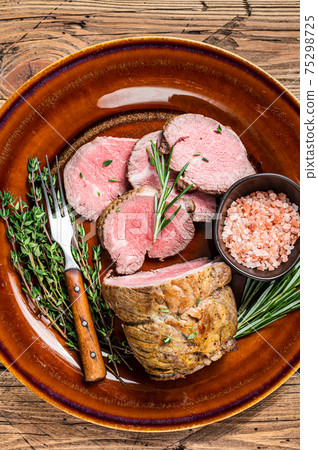 Grilled Roast beef fillet meat on a rustic plate with salt. background. Top view Grilled Roast beef fillet meat on a rustic plate with salt. background. Top view 75298725