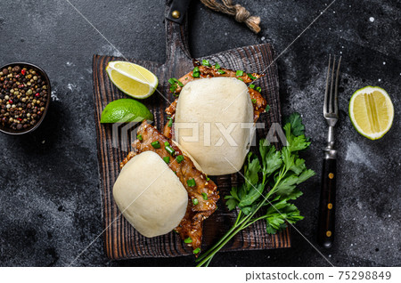 Bun bao steamed with pork belly and vegetables. Black background. Top view Bun bao steamed with pork belly and vegetables. Black background. Top view 75298849