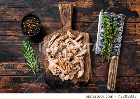 Slow cooked puilled pork meat on a wooden board with butcher cleaver. Dark wooden background. Top view Slow cooked puilled pork meat on a wooden board with butcher cleaver. Dark wooden background. Top view 75298938