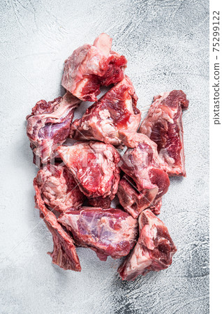 Raw lamb meat stew cuts with bone. White background. Top view Raw lamb meat stew cuts with bone. White background. Top view 75299122