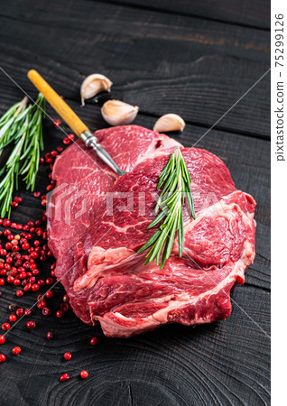 Fresh Raw Chuck eye roll beef steak on butcher table. Black wooden background. Top view Fresh Raw Chuck eye roll beef steak on butcher table. Black wooden background. Top view 75299126