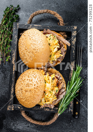 Sandwich with pulled pork meat and coleslaw salad. Black background. Top view Sandwich with pulled pork meat and coleslaw salad. Black background. Top view 75299128