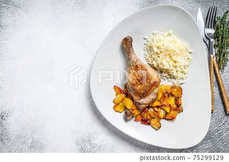 Oven-baked duck legs with figs and peachs. White background. Top view. Copy space Oven-baked duck legs with figs and peachs. White background. Top view. Copy space 75299129