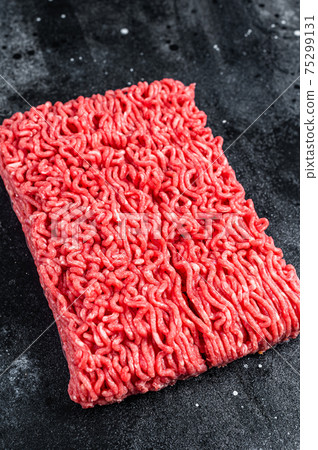 Raw mince beef meat on a kitchen table. Black background. Top view 75299131
