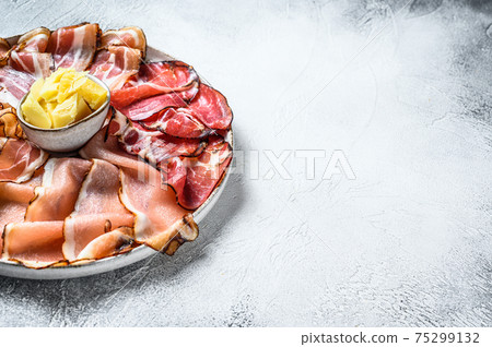Set of cold cured italian meat Ham, prosciutto, pancetta, bacon. White background. Top view. Copy space Set of cold cured italian meat Ham, prosciutto, pancetta, bacon. White background. Top view. Copy space 75299132