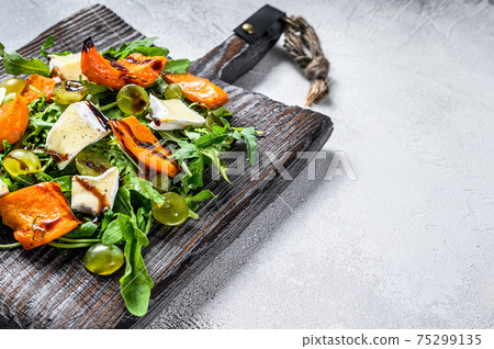 Autumn salad with baked pumpkin and brie cheese. Healthy vegan food concept. White background. Top view. Copy space Autumn salad with baked pumpkin and brie cheese. Healthy vegan food concept. White background. Top view. Copy space 75299135