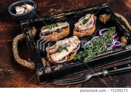 Tapas with sardine and sprat, cream cheese and onion. Dark background. Top view Tapas with sardine and sprat, cream cheese and onion. Dark background. Top view 75299275