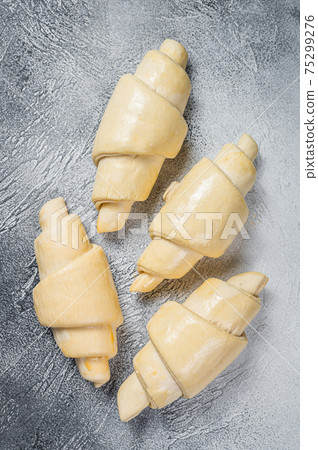 Raw unbaked croissant on kitchen table. White background. Top view 75299276
