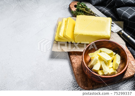 Block of fresh Butter, dairy farm products. Gray background.Top view. Copy space Block of fresh Butter, dairy farm products. Gray background.Top view. Copy space 75299337