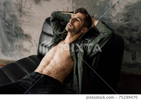 Man with scars at the skin after burn relaxing on comfortable armchair 75299470