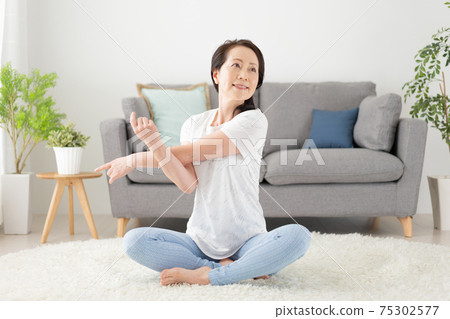 舒展在客廳的資深婦女在家 舒展在客廳的資深婦女在家 75302577