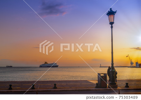 Thessaloniki, Greece Blue Star Mykonos passenger ship sailing to city seaport at sunset. 75303489