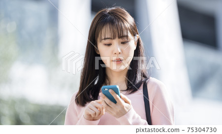 A woman looking for a way with a smartphone A woman looking for a way with a smartphone 75304730