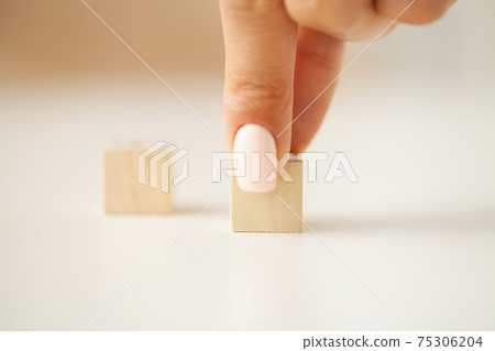 Woman hand putting and stacking blank wooden cubes on desk with copy space for input wording and infographic icon. 75306204