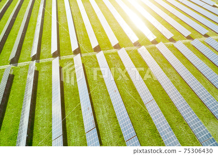 Aerial view of solar power station. Photovoltaic panels field for production of renewable energy. Reflection of sunlight in the panels.  75306430