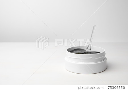 A white box with golden eye patches on the white table with copy space. Cosmetics product for skin care with anti wrinkle effect. A white box with golden eye patches on the white table with copy space. Cosmetics product for skin care with anti wrinkle effect. 75306550