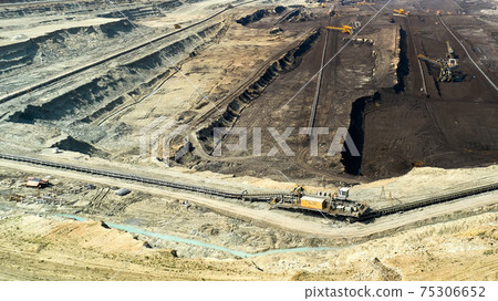 Panoramic view of a quarry with huge machine, bucket wheel excavator mining a coal. Heavy industry Panoramic view of a quarry with huge machine, bucket wheel excavator mining a coal. Heavy industry 75306652