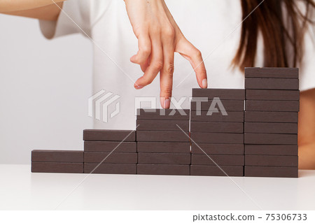 Beautiful young woman demonstrates on wooden bars business development concept Beautiful young woman demonstrates on wooden bars business development concept 75306733