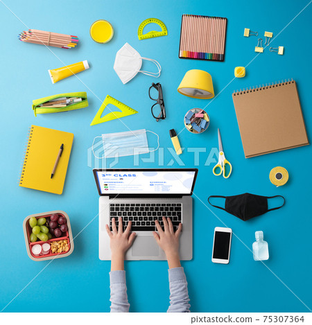 Flat lay top view of face mask and school supplies, distance learning and coronavirus concept. Flat lay top view of face mask and school supplies, distance learning and coronavirus concept. 75307364