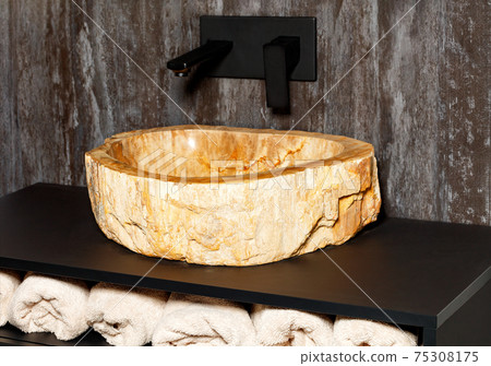 A futuristic washbasin made from a single piece of marble stone. A futuristic washbasin made from a single piece of marble stone. 75308175