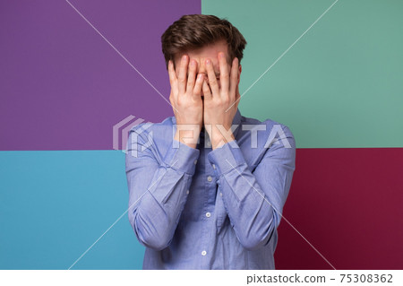 Caucasian man covering his face feeling humiliated. 75308362