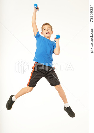 Cute male child holding dumbbells and jumping Cute male child holding dumbbells and jumping 75309324