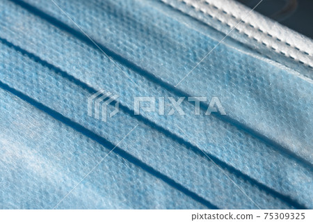 Close up of the front blue surface of a medical or surgical face mask Close up of the front blue surface of a medical or surgical face mask 75309325