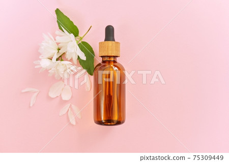 Natural organic cosmetic product in bottle with jasmine flowers on pink background 75309449