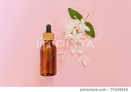 Natural organic cosmetic product in bottle with jasmine flowers on pink background 75309450