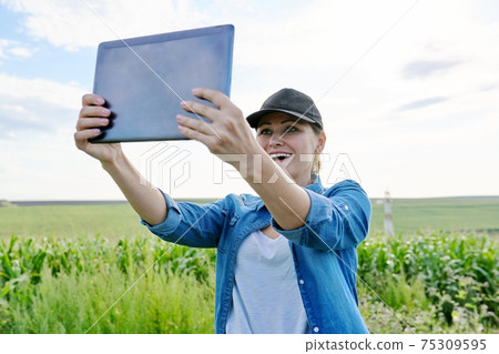 Woman agronomist farmer working with digital tablet in corn field 75309595