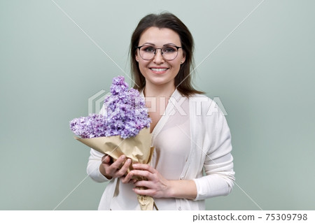 Happy smiling mature woman with bouquet of flowers Happy smiling mature woman with bouquet of flowers 75309798