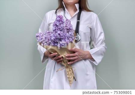 Bouquet of lilac flowers in the hands of female doctor with stethoscope Bouquet of lilac flowers in the hands of female doctor with stethoscope 75309801