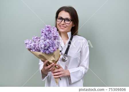 Smiling mature woman doctor nurse with bouquet of flowers, gift, celebration, medical worker day Smiling mature woman doctor nurse with bouquet of flowers, gift, celebration, medical worker day 75309806