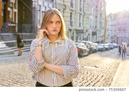 Portrait of a sad young woman in the city, offended beautiful blonde 75309807
