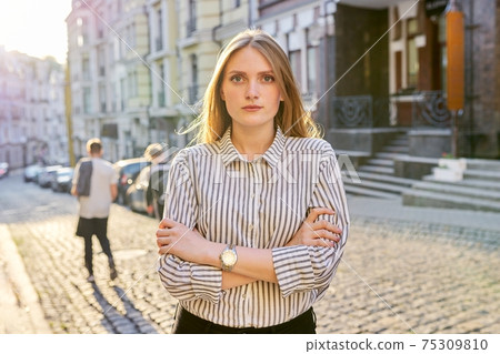 Urban portrait of beautiful young blonde woman on city street at sunset Urban portrait of beautiful young blonde woman on city street at sunset 75309810