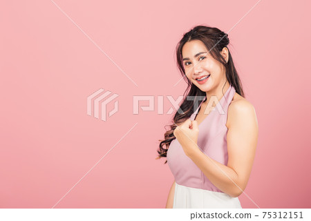 woman stand makes raised fists up celebrating her winning success gesture woman stand makes raised fists up celebrating her winning success gesture 75312151