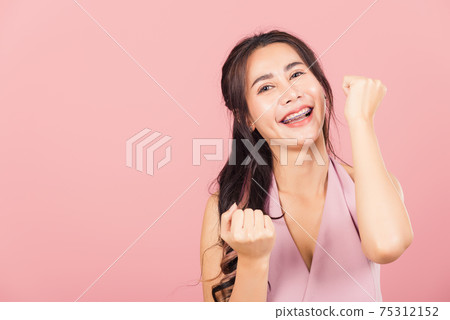 woman standing winning and surprised excited woman standing winning and surprised excited 75312152
