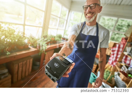 Selective focus on bank terminal in man hand 75312393