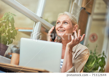 Middle aged caucasian business woman talking on phone Middle aged caucasian business woman talking on phone 75312644