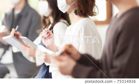 Students taking notes with a tablet [Wearing a mask] 75314916