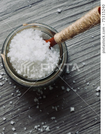 Sea salt in a glass container and a wooden spoon 75315240