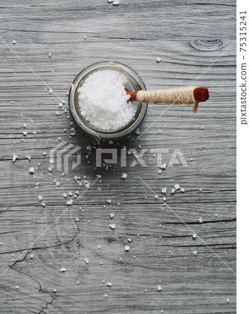 Sea salt in a glass container and a wooden spoon 75315241