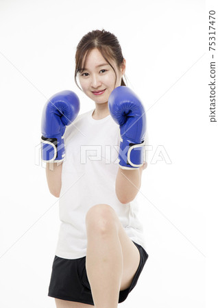 Young woman practicing kickboxing 75317470