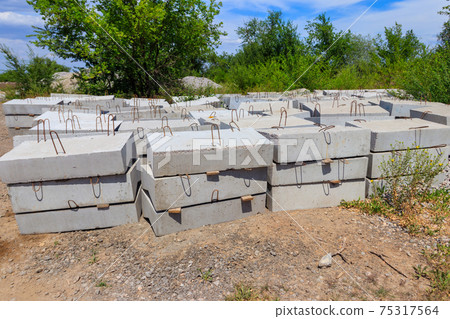 Stacks of the new concrete road curbs for road construction 75317564